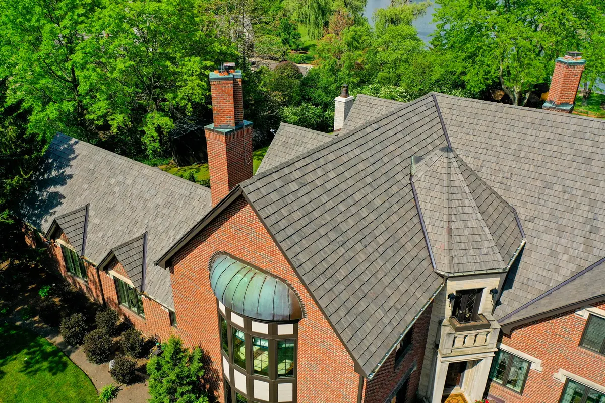 Brick Tudor home with a Brava Cedar Shake roof in Lake Forest, including a shake-clad turret