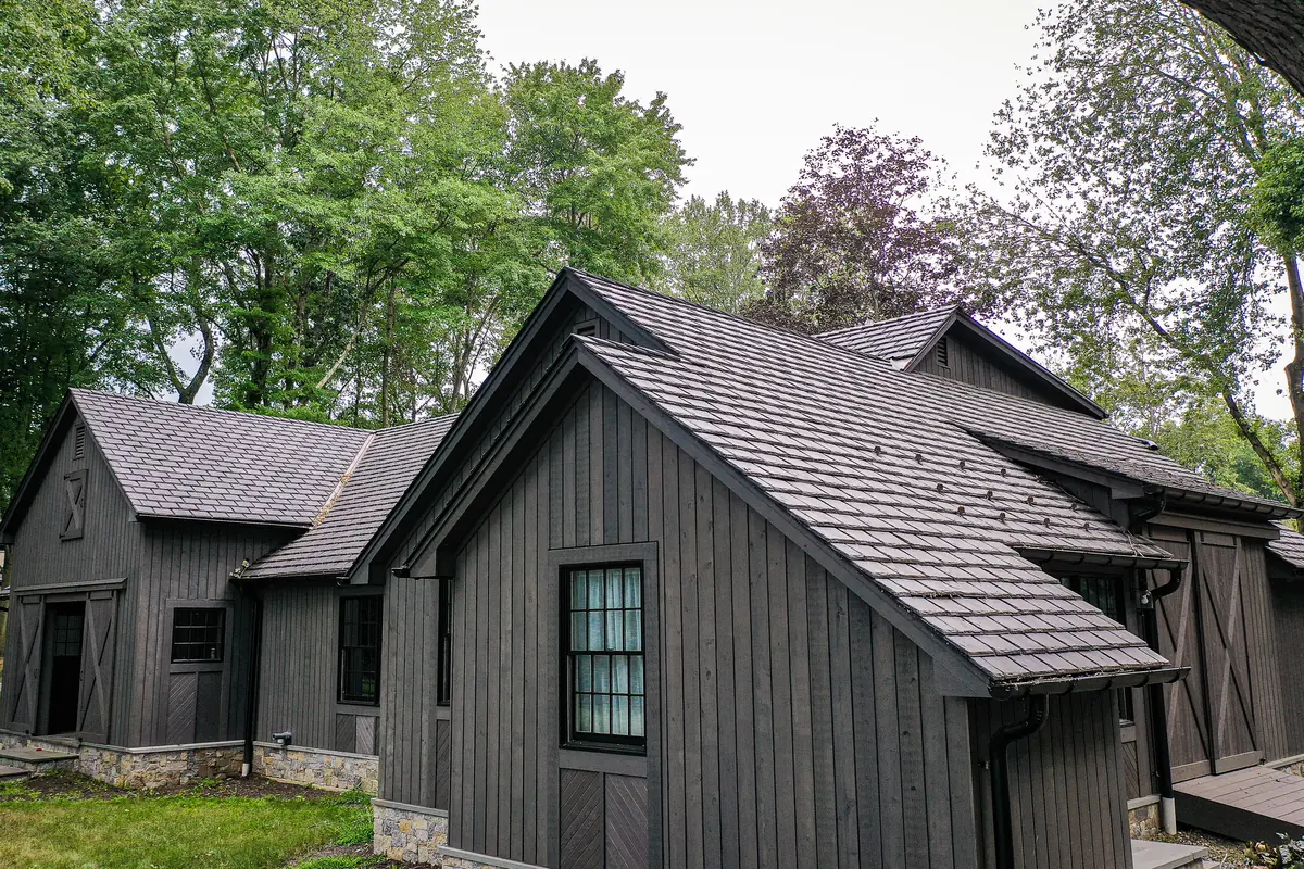 Dark board-and-batten home with a Brava Old World Slate roof in Arendale
