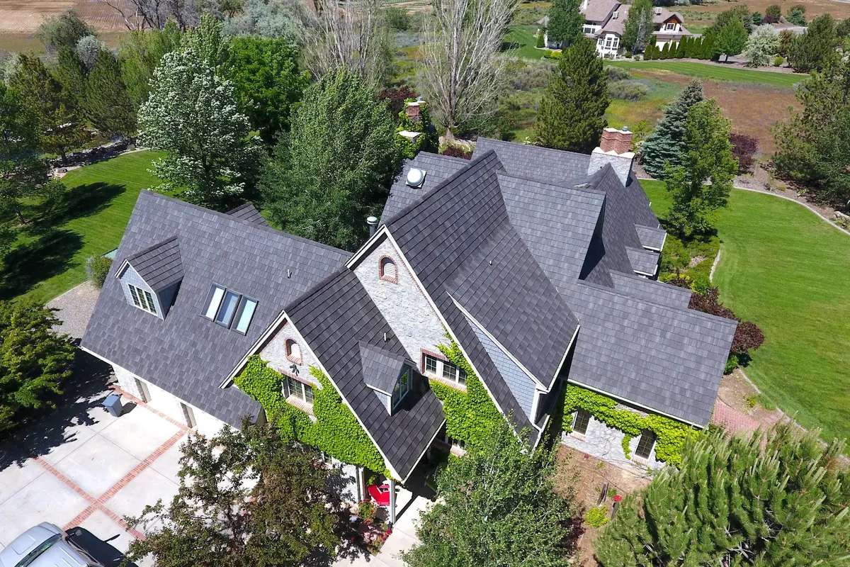 Aerial view of a stone house with a DaVinci Multi-Width Shake roof in Mountain, with dormers and skylights