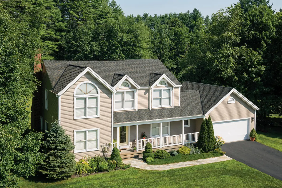 Beige colonial with gabled dormers and an IKO Dynasty roof in Biscayne