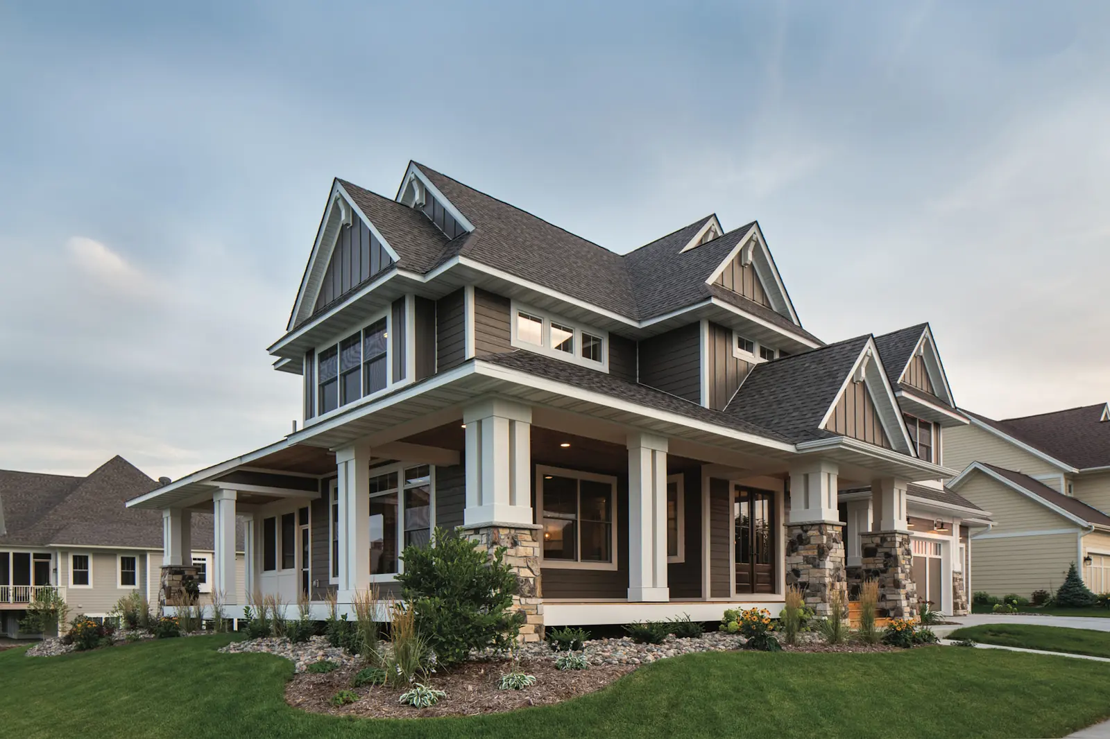Craftsman home with brown LP SmartSide lap siding, white trim, and stone porch columns