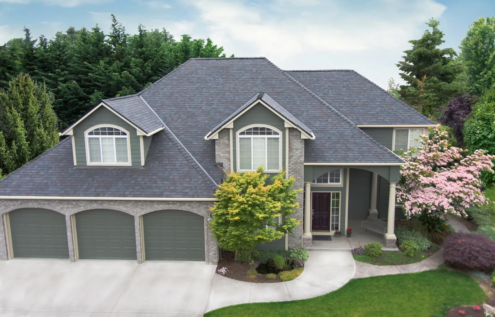 Two-story house with three garage doors and a Malarkey Legacy roof in Black Oak