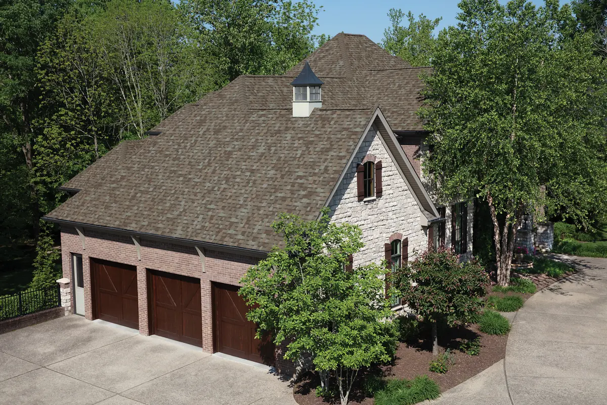 Brick and stone home with an Owens Corning TruDefinition Duration roof in Driftwood