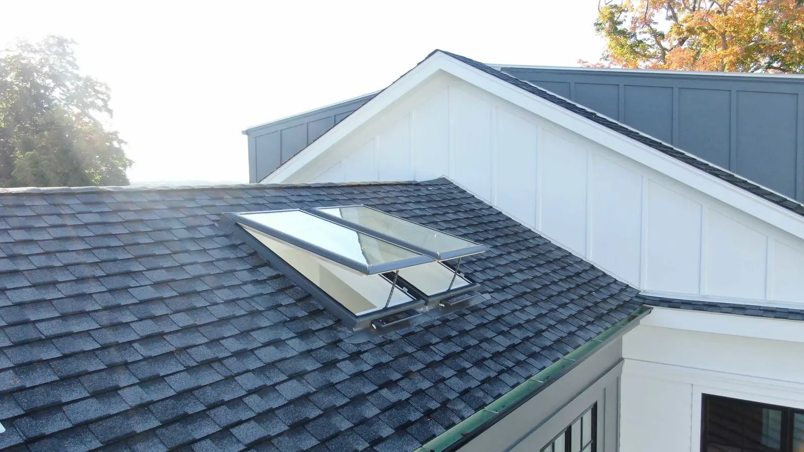Two open VELUX venting skylights flashed into an asphalt shingle roof
