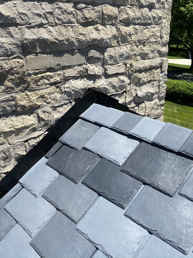 DaVinci synthetic slate tiles with black flashing against stone wall