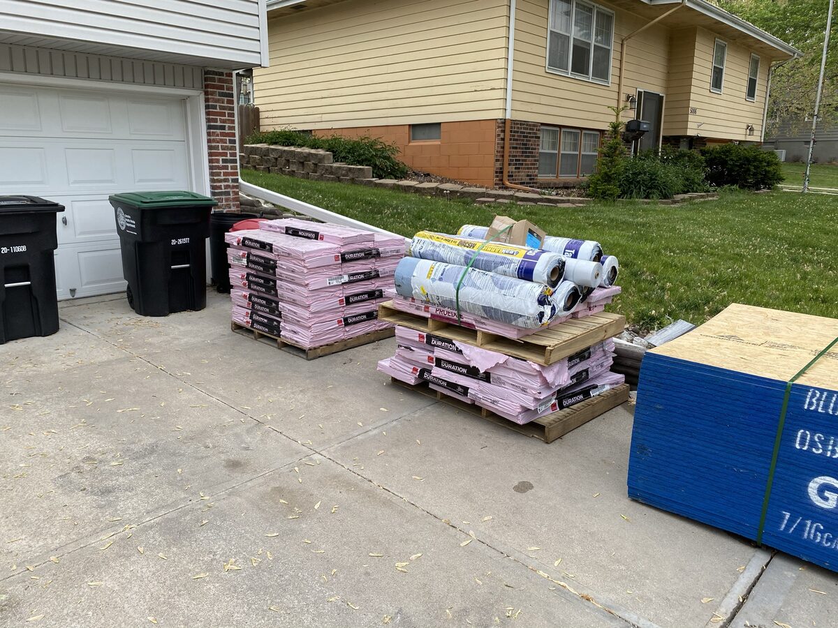 Roofing materials staged in driveway before Omaha roof replacement