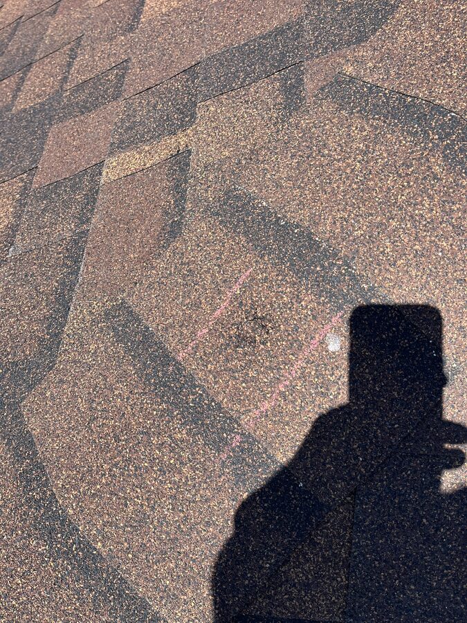 Hail-dented shingles documented during a roof inspection